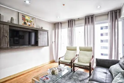 a living room with two chairs and a tv at Upper Pardo Apartments in Lima