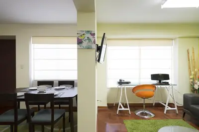 a living room with a table and a chair at La Masia Apartments in Lima