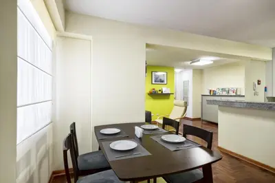 a dining room with a table and chairs at La Masia Apartments in Lima