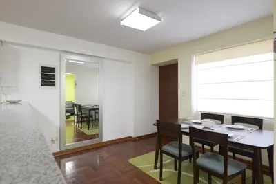 a dining room with a table and chairs at La Masia Apartments in Lima