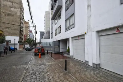 a street with a car parked next to a building at La Masia Apartments in Lima