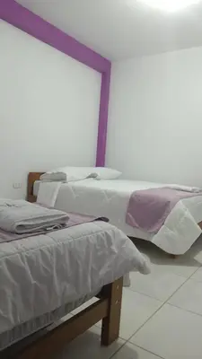 two beds in a room with a window at Hospedaje Bella Acuarela in Oxapampa