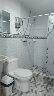 a white bathroom with a toilet and a sink at Hospedaje Bella Acuarela in Oxapampa