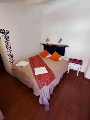 a bedroom with a bed with orange pillows at Apartamento Familiar con balcón y vista a la Ciudad, Centro in Cusco