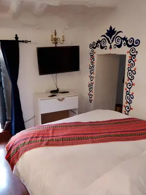 a bedroom with a bed and a flat screen tv at Apartamento Familiar con balcón y vista a la Ciudad, Centro in Cusco