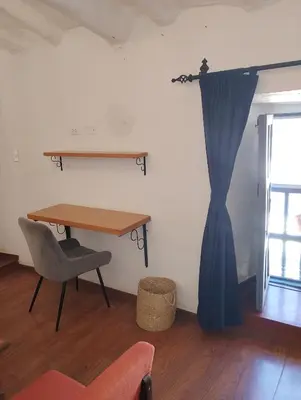 a table and a chair and a blue curtain in a room at Apartamento Familiar con balcón y vista a la Ciudad, Centro in Cusco