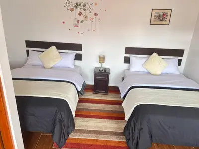 a bedroom with two beds and a night stand at Cusco and Rock in Cusco