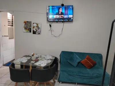 a living room with a table and a couch and a television at loft Inti in Cusco