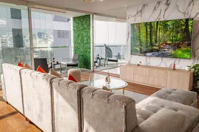 a living room with couches and a large tv at Espectacular vista al mar en Miraflores in Lima