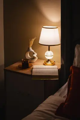 a table with a lamp and a book on a bed at Espectacular vista al mar en Miraflores in Lima