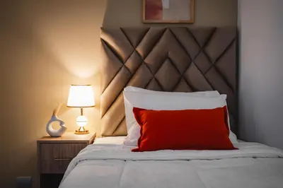 a bed with a red pillow and a lamp at Espectacular vista al mar en Miraflores in Lima