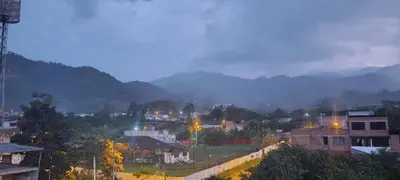 a city at night with mountains in the background at Casa San Ramón in San Ramón