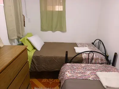 a room with two beds and a dresser at Sumaq Tika in Cusco