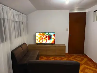 a living room with a couch and a flat screen tv at Sumaq Tika in Cusco