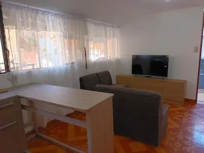 a living room with a table and a television at Sumaq Tika in Cusco