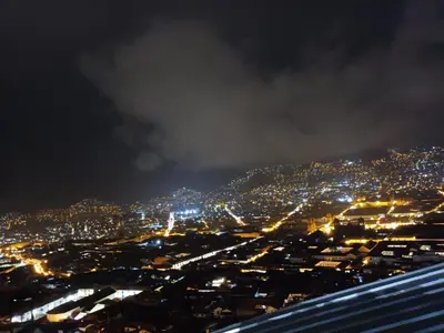 a view of a city at night with lights at Hanan Pacha in Cusco
