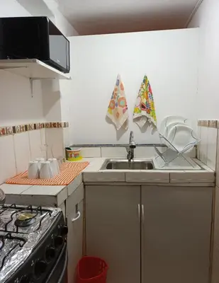 a kitchen with a sink and a stove at Yuraq Wasicha in Cusco