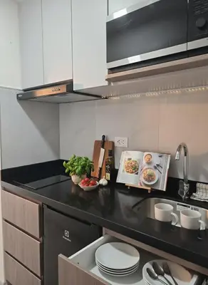 a kitchen with a black counter top with white cabinets at Apartment suite in the heart of Miraflores! in Lima