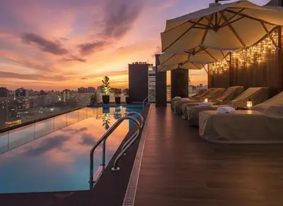 a rooftop pool with lounge chairs and an umbrella at Apartment suite in the heart of Miraflores! in Lima