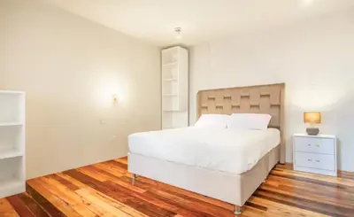a bedroom with a large white bed and a night stand at Corazón de Cusco 2 in Cusco