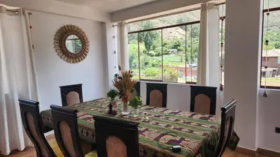 a dining room with a table and chairs and a window at Chakana Wasi in Calca