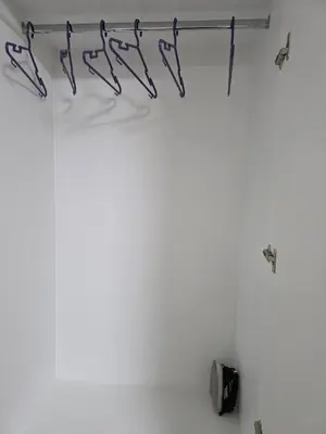 a room with a white wall with a rack of weapons at Departamento equipado, cómodo, tranquilo y céntrico in Lima