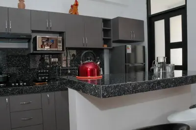 a kitchen with black granite counter tops and a red appliance at Valle Sagrado Mágico in Urubamba