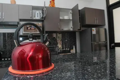 a red tea kettle sitting on top of a kitchen counter at Valle Sagrado Mágico in Urubamba