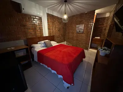 a bedroom with a bed with a red blanket at La Fogata del Sur in Asia