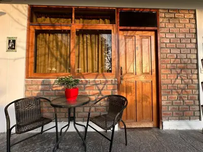 a table and two chairs in front of a door at La Fogata del Sur in Asia