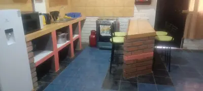 a kitchen with a refrigerator and a counter with stools at Cozy Rural House in Apata - Jauja