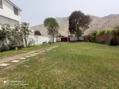 an empty yard next to a building with mountains in the background at Cieneguilla Casa in Cieneguilla