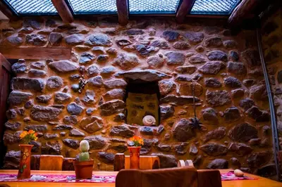 a stone wall in a restaurant with a table at Stone house in Ollantaytambo in Ollantaytambo