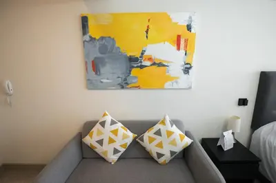 a living room with a couch and a painting on the wall at iStay Acogedor Loft Piscina BBQ Gym Bicicleta in Lima
