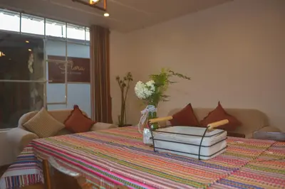 a table with books and a vase of flowers on it at La Casa de Toño in Huancayo