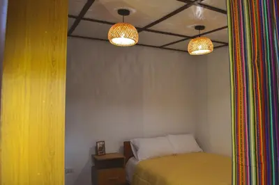 a bedroom with two lights and a bed in a room at La Casa de Toño in Huancayo