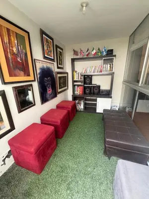 a living room with red ottomans and a room with a green carpet at Comfortable apartment in downtown area - 3 bedrooms in Lima