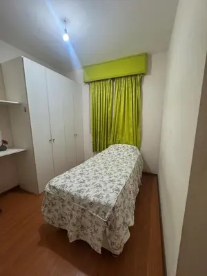 a small room with a bed and a green curtain at Comfortable apartment in downtown area - 3 bedrooms in Lima