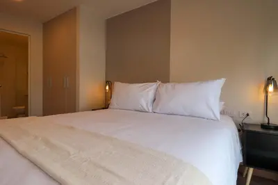 a large bed with white sheets and pillows at Schell in Miraflores by Wynwood House in Lima