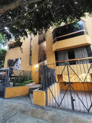 a yellow building with a gate in front of it at Céntrica habitación con vistas Larcomar in Lima