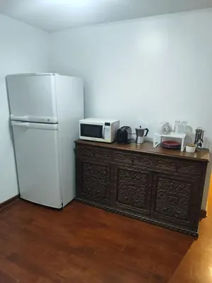 a kitchen with a refrigerator and a microwave on a dresser at Cómoda y céntrica habitación Larcomar in Lima