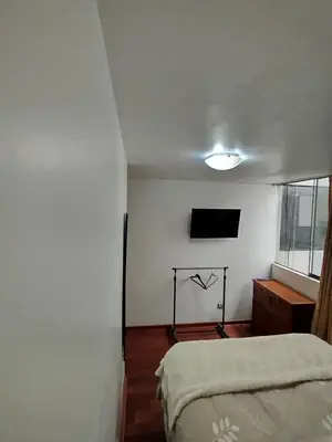 a bedroom with a bed and a flat screen tv at Cómoda y céntrica habitación Larcomar in Lima