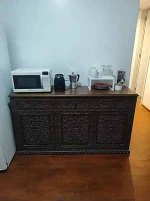 a wooden cabinet with a microwave on top of it at Cómoda y céntrica habitación Larcomar in Lima