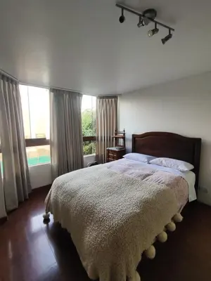 a bedroom with a large bed and a large window at Amplia y céntrica habitación con vistas Larcomar in Lima