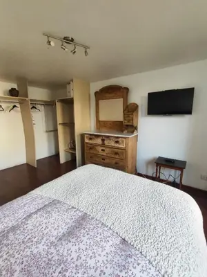 a bedroom with a bed and a dresser and a television at Amplia y céntrica habitación con vistas Larcomar in Lima