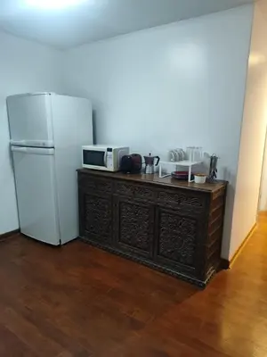 a kitchen with a microwave and a refrigerator at Amplia y céntrica habitación con vistas Larcomar in Lima
