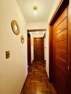 a hallway with a wooden floor and a door at Departamento en Cusco NAIRA in Cusco