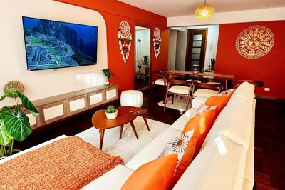 a living room with a white couch and a table at Departamento en Cusco NAIRA in Cusco