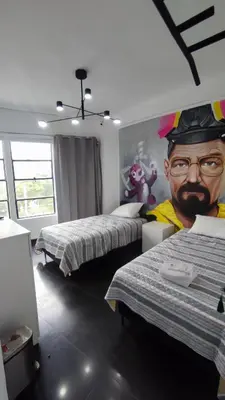 a room with two beds and a mural of a man at PintoHome in Lima