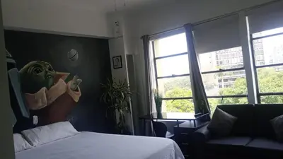 a bedroom with a bed and a couch and a window at PintoHome in Lima